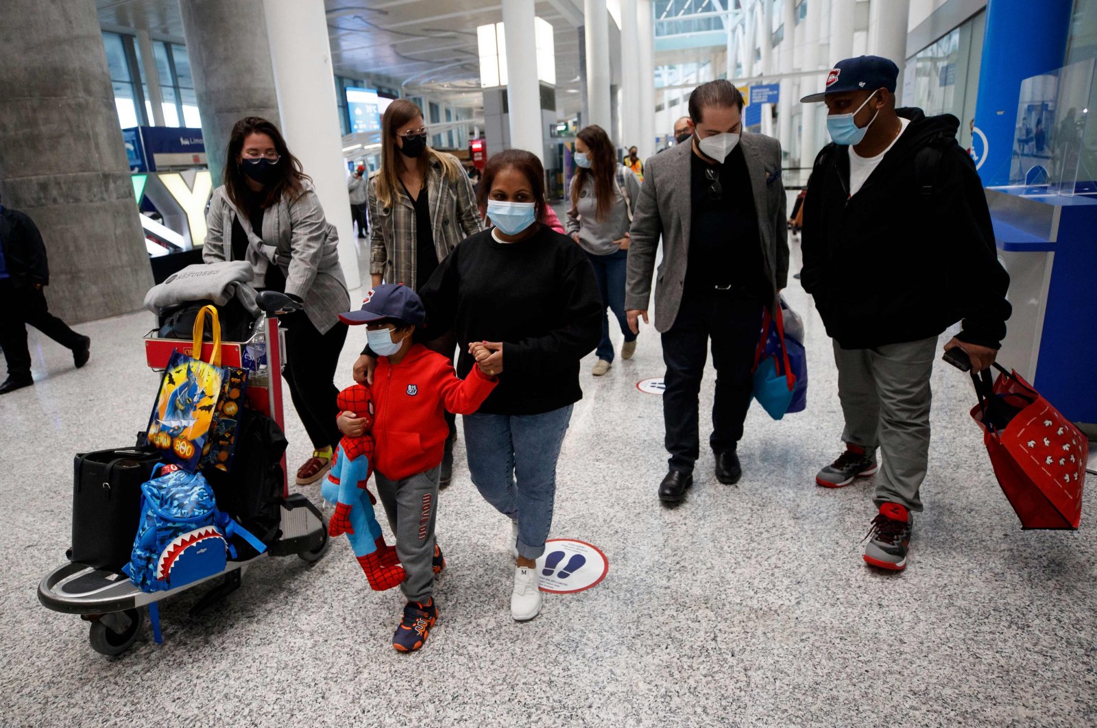 Nadeeka Dilrukshi Nonis holds the hand of her son Dinath, and Supun Thilina Kellapatha (R) speaks with lawyer Marc-Andre Seguin (2R), as they arrive in Canada as refugees at Pearson International Airport in Toronto, Ontario, Canada, Sept. 28, 2021. (AFP Photo)