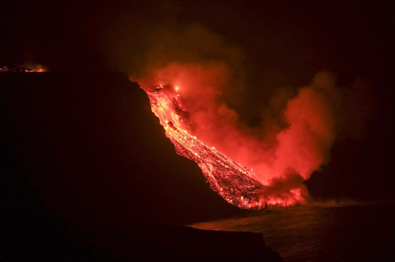 Lava flow from the Cumbre Vieja volcanic eruption in La Palma reaching the sea tonight in an area of cliffs next to Tazacortes coast in La Palma, Canary Islands, Sept. 28, 2021. (EPA Photo)