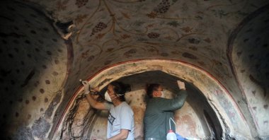 Two archaeologists work on the wall motifs of a room inside a rock tomb in the ancient city of Blaundus, Uşak, western Turkey, Sept. 29, 2021. (AA Photo) 