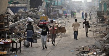 Earthquake survivors walk in a street with debris in downtown Port-au-Prince March 16, 2010. (Reuters File Photo)