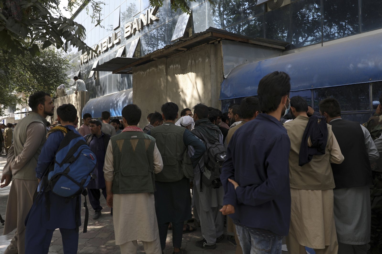 Afghans wait in long lines for hours to try to withdraw money in front of a bank in Kabul, Afghanistan, Sunday, Aug. 15, 2021. (AP Photo)