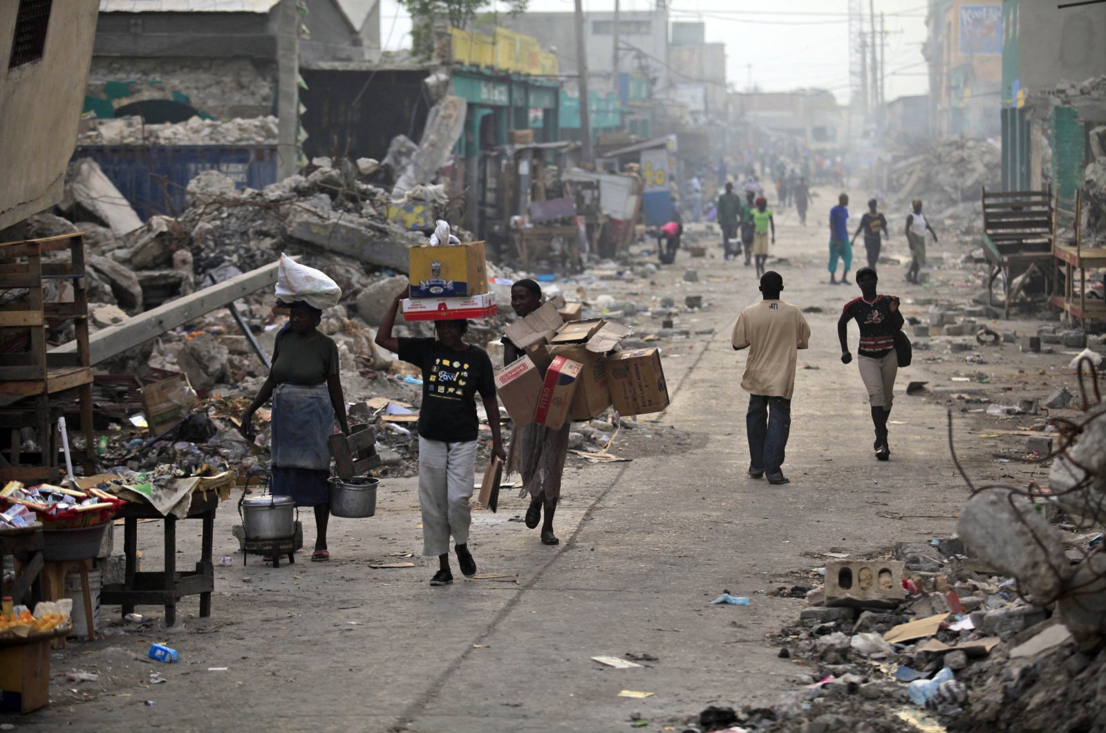 Earthquake survivors walk in a street with debris in downtown Port-au-Prince March 16, 2010. (Reuters File Photo)
