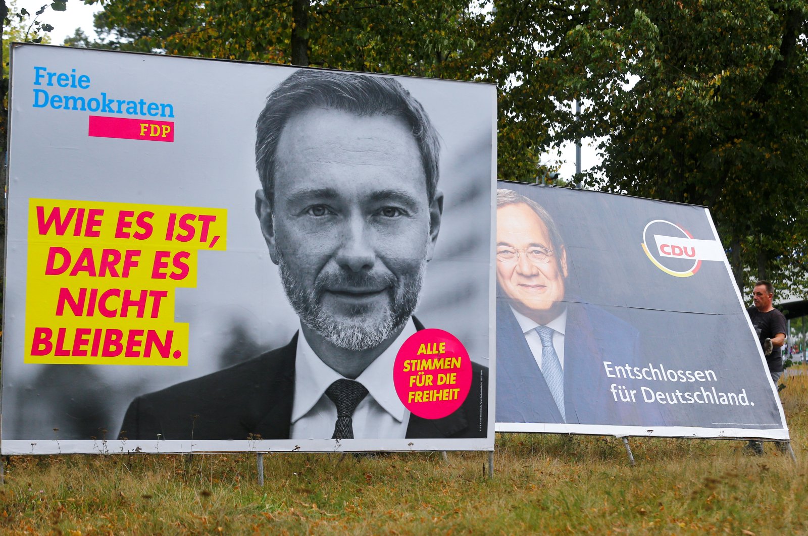 Workers remove election campaign posters showing Free Democratic Party (FDP) leader Christian Lindner (L) and Armin Laschet, chancellor candidate for Germany's Christian Democratic Union (R), the day after the general election, Cologne, Germany, Sept. 27, 2021. (Reuters Photo)