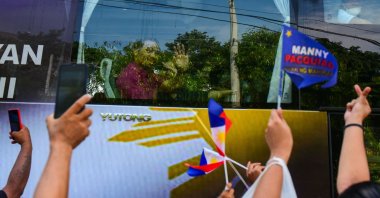 Philippine boxing icon and senator Manny Pacquiao waves to supporters as he arrives in a bus to file his certicate of candidacy for the Philippine presidency in Manila on Oct. 1, 2021. (Photo by Maria Tan / AFP)