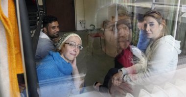 Boshra al-Moallem (foreground L), looks out of the window as she sits in a room with her two sisters and brother-in-law at a refugee center in Bialystok, Poland, Sept. 29, 2021. (AP Photo)