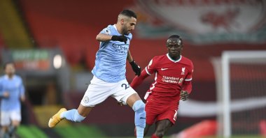 Manchester City's Riyad Mahrez (L) drives the ball past Liverpool's Sadio Mane in a Premier League match at the Anfield, Liverpool, England, Feb. 7, 2021. (AP Photo)