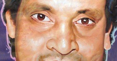 A Pakistani man walks past a huge portrait of Pakistani comedian and stage actor Umar Sharif outside a theater in Rawalpindi on the outskirts of Islamabad, Pakistan, Jan. 21, 2002. (Reuters Photo)