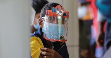A Sri Lankan boy with a face shield with his hero receives his COVID-19 vaccine at a Hospital during an island-wide lockdown as a preventive measure against the spread of COVID-19, Colombo, Sri Lanka, Sept. 30, 2021. (EPA Photo)