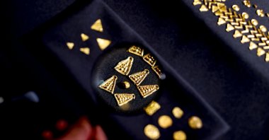 An official shows artifacts found in the ancient city of Phanagoria through a magnifying glass, Russia, Oct. 1, 2021. (AA Photo) 