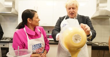 Britain's Prime Minister Boris Johnson and Home Secretary Priti Patel try baking during a visit to HideOut Youth Zone, in Manchester, England, Oct. 3, 2021. (AP Photo)