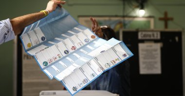 A man receives his ballots at a polling station, in Rome, Italy, Oct. 3, 2021. (AP Photo)