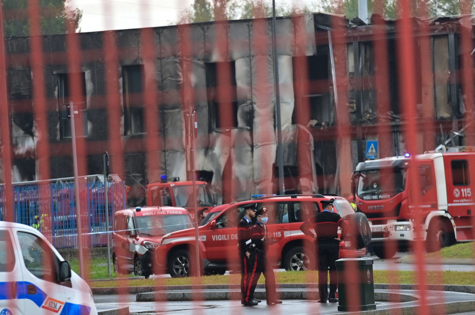 Police and rescue teams stand outside an apparently vacant office building where a small plane carrying eight people crashed in the Milan suburb of San Donato, Italy, Oct. 3, 2021. (AFP Photo)