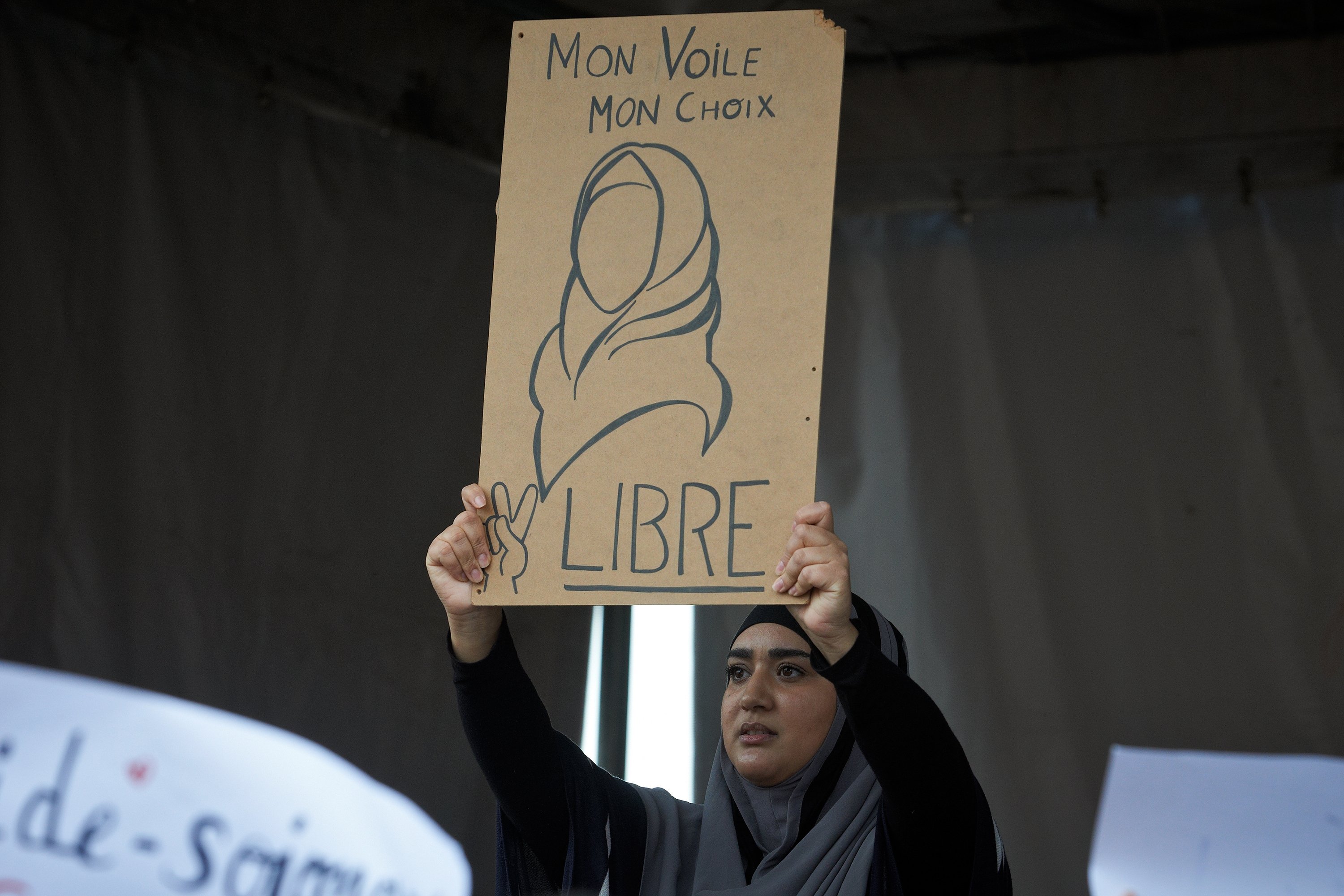 Une femme avec un foulard montre un dessin indiquant 'Mon voile, mon choix, libre.'  Des personnes se sont rassemblées contre l'islamophobie sur la place principale de Toulouse, en France, le 27 octobre 2019. (Photo Getty Images)