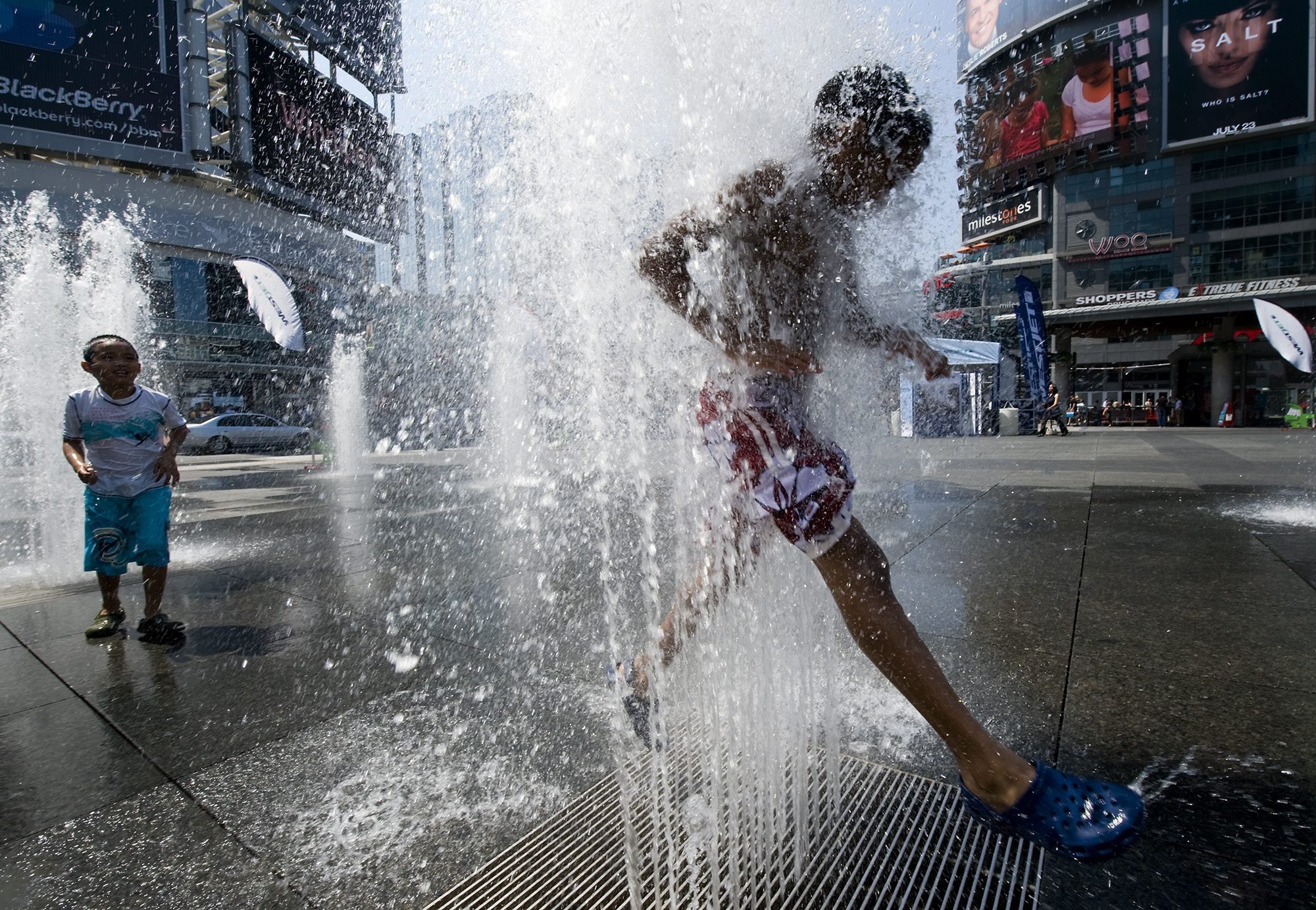 Ty Lewis, 8, right, and Ryan Chase, 7, cool off in the fountains at Dundas Square, as a heatwave strikes Toronto, Canada, July 8, 2010. (AP Photo)