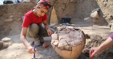 Archaeologists work on the 4,500-year-old jar in the Yumuktepe Mound, Mersin, southern Turkey, Oct. 3, 2021. (AA Photo) 