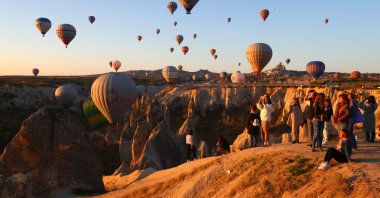 Tourists watch and take photographs as air balloons take to the sky, in Nevşehir, Turkey, Oct. 3, 2021. (AA Photo)