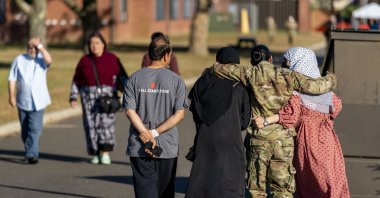 A female member of the U.S. military puts her arms around two female Afghan refugees after they spoke with Secretary of Defense Lloyd Austin as he visits an Afghan refugee camp on Joint Base McGuire Dix Lakehurst, New Jersey, U.S., Sept. 27, 2021. (AP Photo)