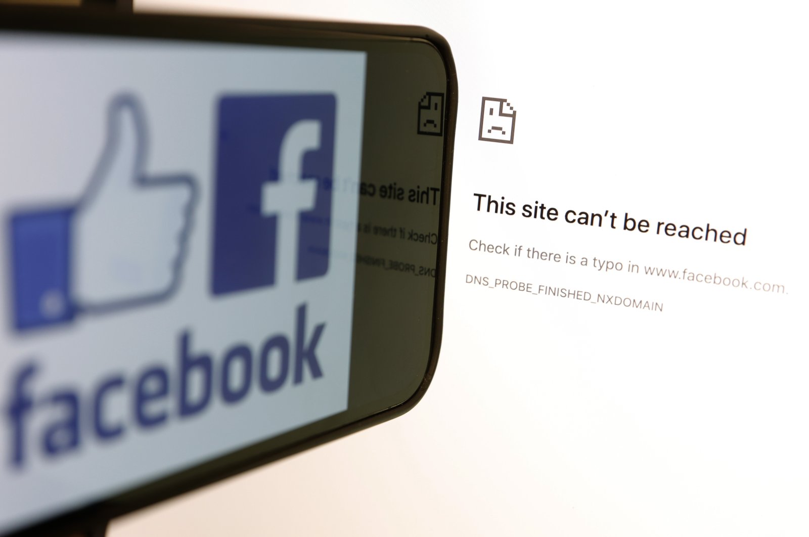The Facebook logo is displayed next to a screen showing that Facebook service is down on Oct. 4, 2021 in San Anselmo, California. (Photo Illustration by Justin Sullivan/Getty Images)