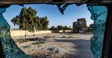 Syrian students walking to school are seen through shattered glass in the northern city of Raqqa, Syria, Sept. 23, 2021. (AFP Photo)