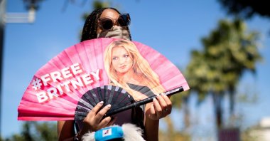 A supporter holds a fan while rallying for pop star Britney Spears during a conservatorship case hearing at Stanley Mosk Courthouse in Los Angeles, California, U.S., March 17, 2021.  (Reuters Photo)