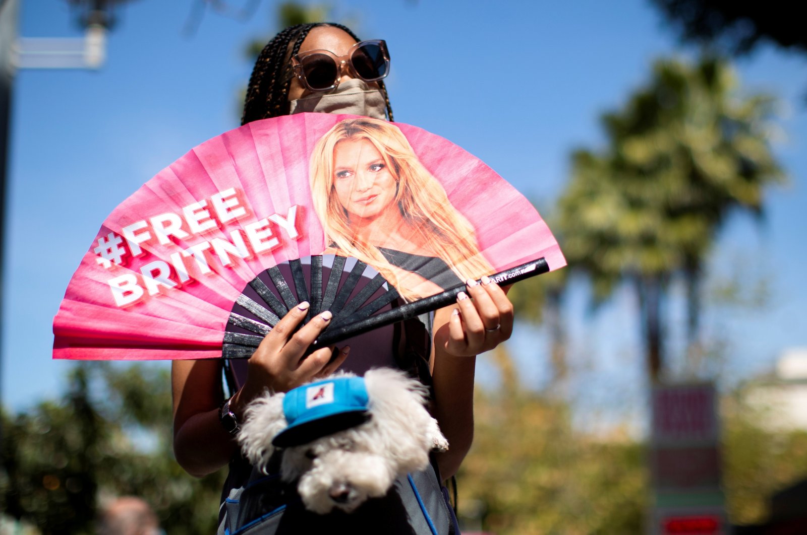 A supporter holds a fan while rallying for pop star Britney Spears during a conservatorship case hearing at Stanley Mosk Courthouse in Los Angeles, California, U.S., March 17, 2021.  (Reuters Photo)