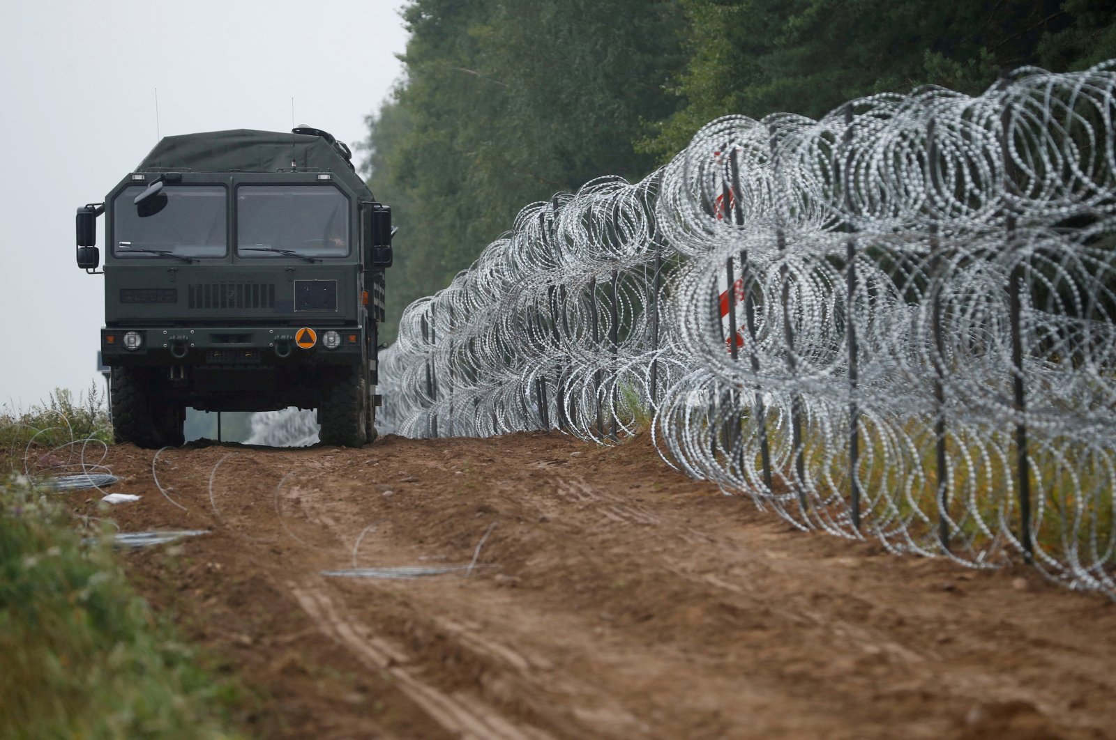 A military vehicle is seen next to a fence built by Polish soldiers on the border between Poland and Belarus near the village of Nomiki, Poland, Aug. 26, 2021. (Reuters Photo)