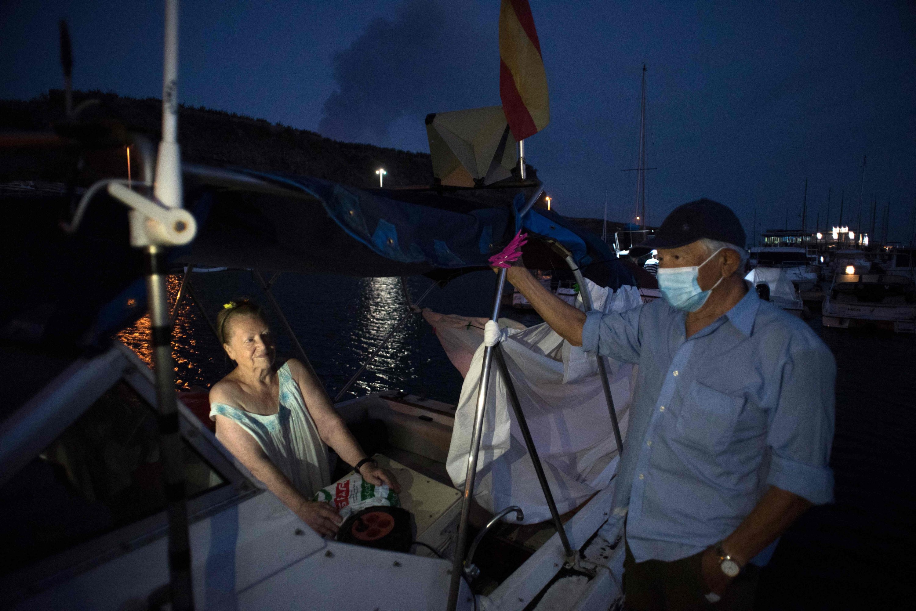 Margaretha and Luis, 80 and 90 years old, wait on their boat where they have settled after fleeing their home after the eruption of the Cumbre Vieja volcano, in the port of Tazacorte, on La Palma, Spain, Oct. 3, 2021. (AFP Photo)