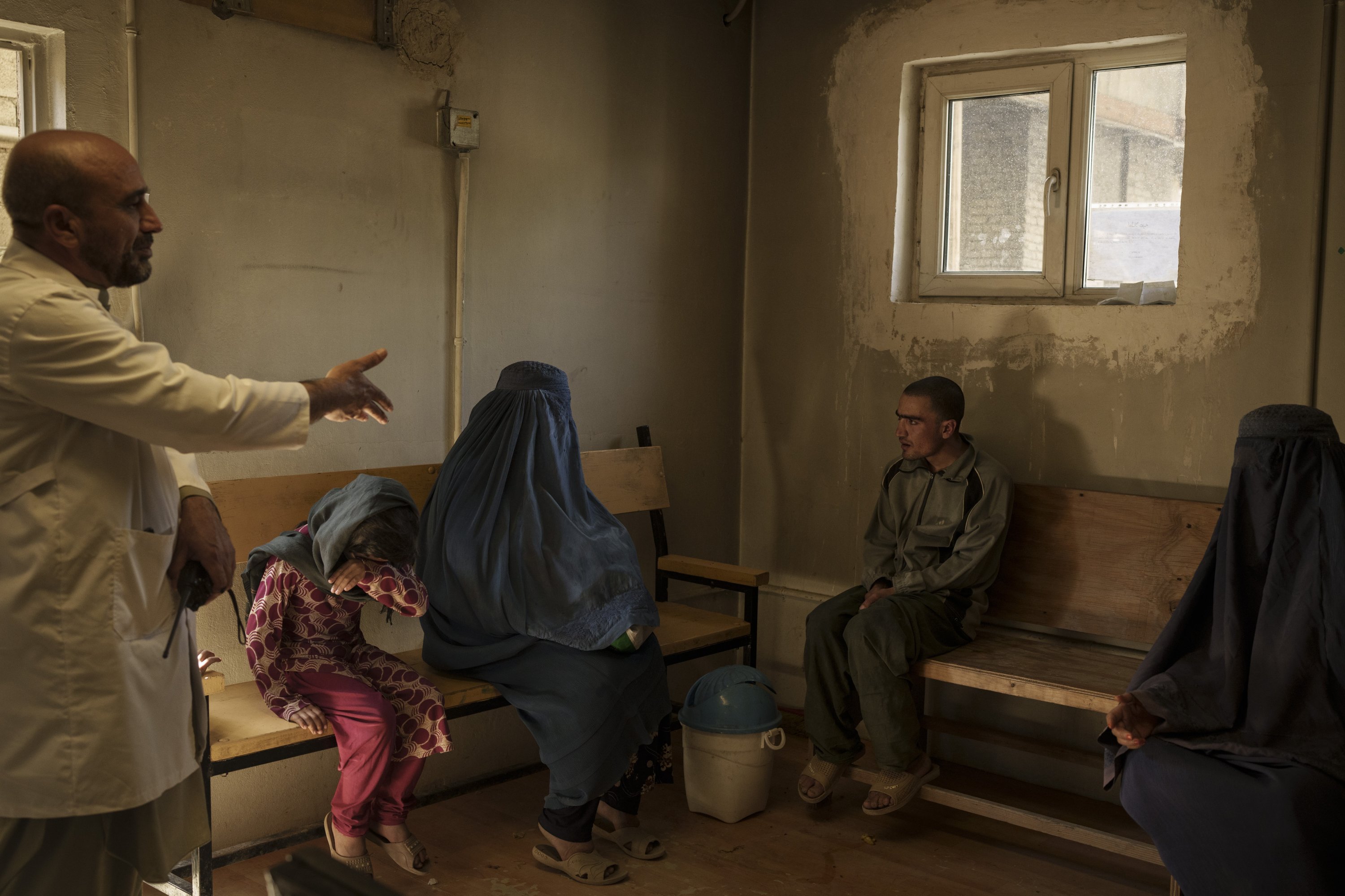 Dr. Wahedullah Koshan (L) gestures as he talks to Sitara (C) after she reunited with her 21-year-old son who was taken to the Avicenna Medical Hospital for Drug Treatment during a Taliban raid in Kabul, Afghanistan, Oct. 4, 2021. (AP Photo)