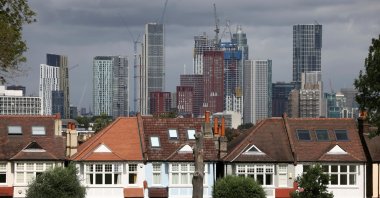 High-rise apartments under construction can be seen in the distance behind a row of residential housing in south London, Britain, Aug. 6, 2021. (Reuters Photo)