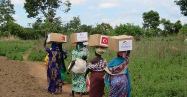 Ugandan women carry aid packages donated by Turkey's TIKA, in Yumbe, Uganda, May 7, 2021. (Courtesy of TIKA)