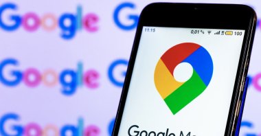 In this photo illustration, a Google Maps logo is seen displayed on a smartphone screen in front of a computer screen. (Reuters Photo)