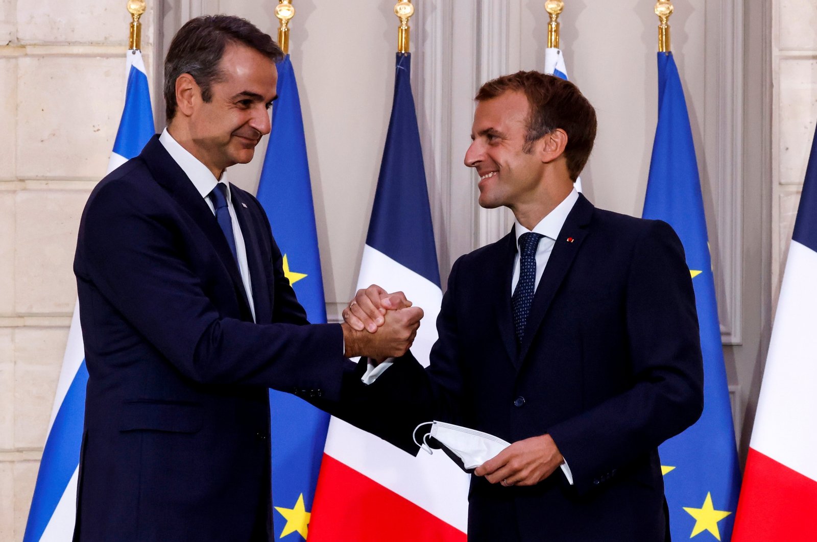 Greek Prime Minister Kyriakos Mitsotakis shakes hands with French President Emmanuel Macron following a signing ceremony of a new defense deal at the Elysee Palace in Paris, France Sept. 28, 2021. (Reuters File Photo)