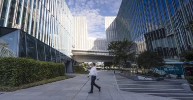A man walks in front of the Sinic Holdings Shanghai headquarters building in Shanghai, China, Oct. 6, 2021. (EPA Photo)