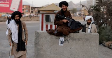 Taliban fighter Mira Jan Himmat, 30, and Rafiullah, 26, from Helmand province smile as they stand guard in a checkpoint in Kabul, Afghanistan, Oct. 5, 2021. (Reuters File Photo)