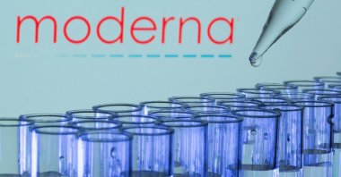 Test tubes are seen in front of a displayed Moderna logo in this illustration, May 21, 2021. (Reuters Photo)