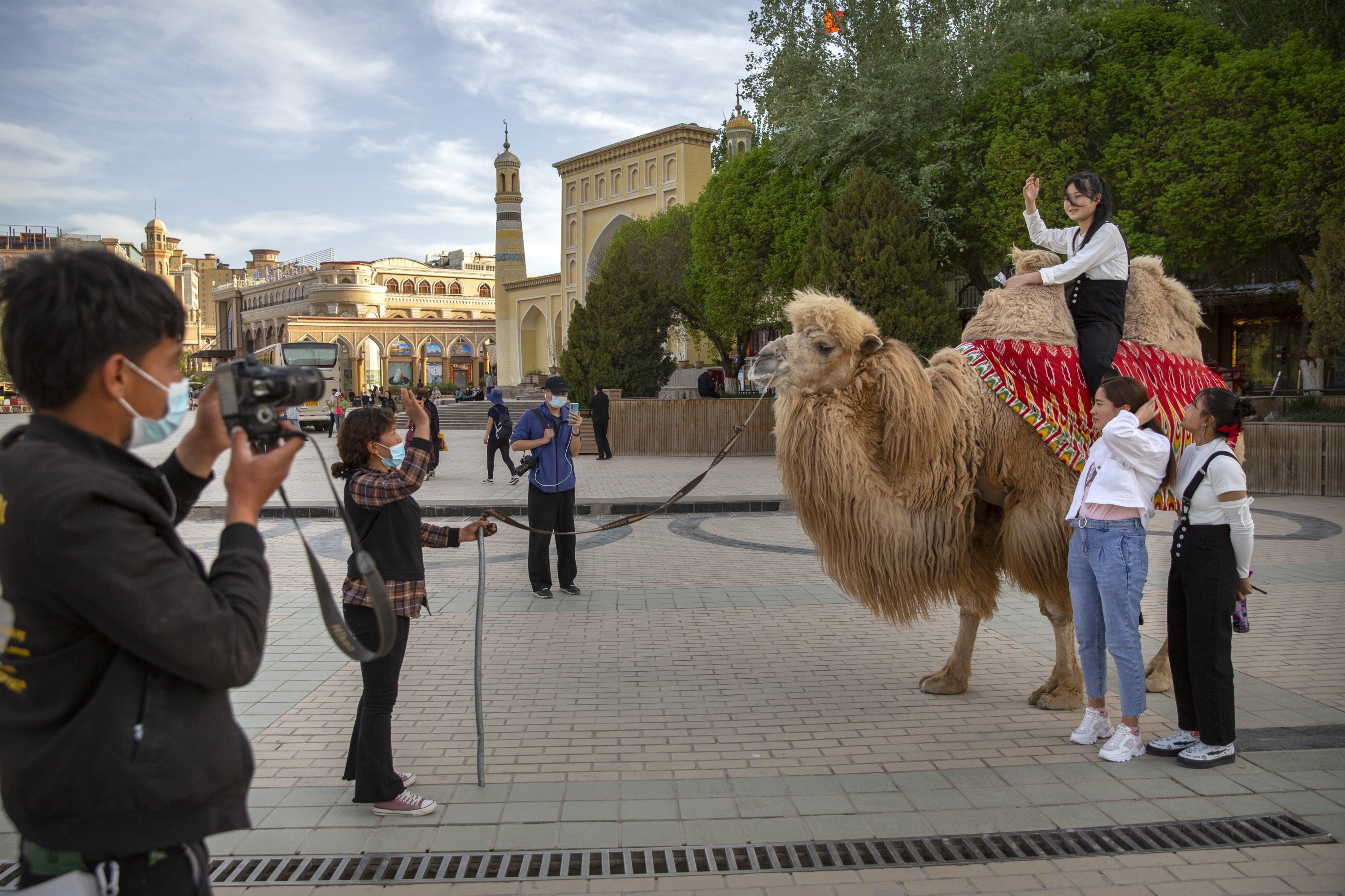 Tourists pose for photos as one of them sits atop a camel outside the Id Kah Mosque in Kashgar, Xinjiang Uyghur Autonomous Region, China, April 19, 2021. (AP Photo)
