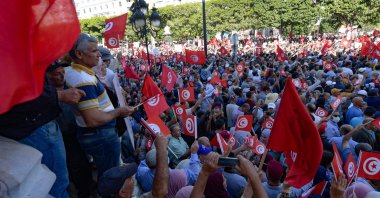 Tunisians raise national flags during a rally against their president along the Habib Bourguiba avenue in the capital Tunis, Oct. 10, 2021. (AFP Photo)