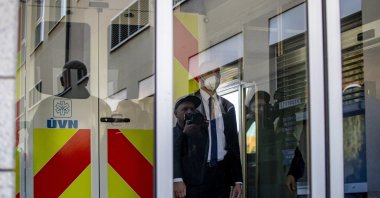 Media members are reflected in a glass door as security guards an ambulance carrying Czech President Milos Zeman arriving at the Central Military Hospital in Prague, Czech Republic, Oct. 10, 2021. (EPA Photo)