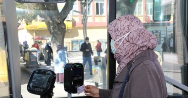 A passenger scans her electronic pass in a bus, in Afyon, western Turkey, Oct. 5, 2021. (AA Photo)