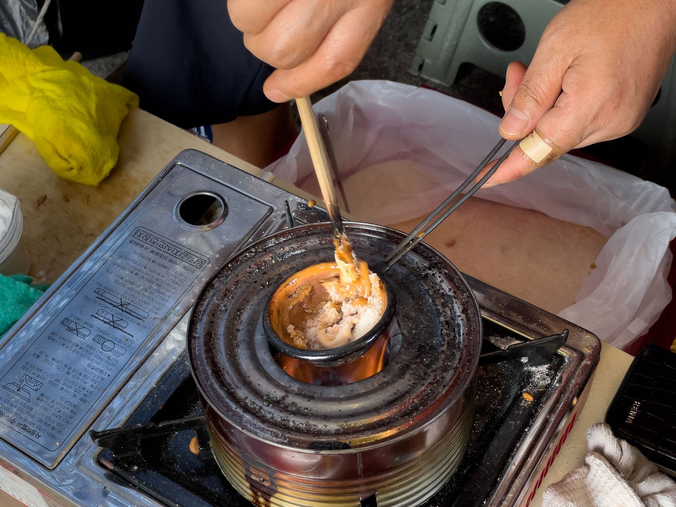 Street vendor Jung Jung-soon makes a dalgona, a crisp sugar candy featured in the Netflix smash hit series "Squid Game," in Seoul, South Korea, Oct. 10, 2021. (AFP Photo)