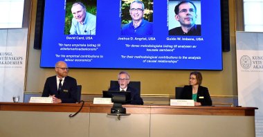 Royal Swedish Academy of Sciences Secretary General Goran K. Hansson (C) and members of the academy's Economic Sciences Prize Committee 2021 Peter Fredriksson (L) and Eva Moerk announce the Sveriges Riksbank Prize in Economic Sciences in Memory of Alfred Nobel 2021 as photographs of the winners David Card, Joshua Angrist and Guido Imbens are presented on a screen during a news conference at the academy, in Stockholm, Sweden, Oct. 11, 2021. (Claudio Bresciani/TT News Agency via Reuters)