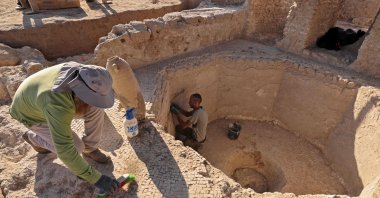 Archaeologists and technicians of the Israel Antiquities Authority excavate inside a collecting vat of a winepress at the Tel Yavne site in central Israel, Oct. 11, 2021. (AFP Photo)