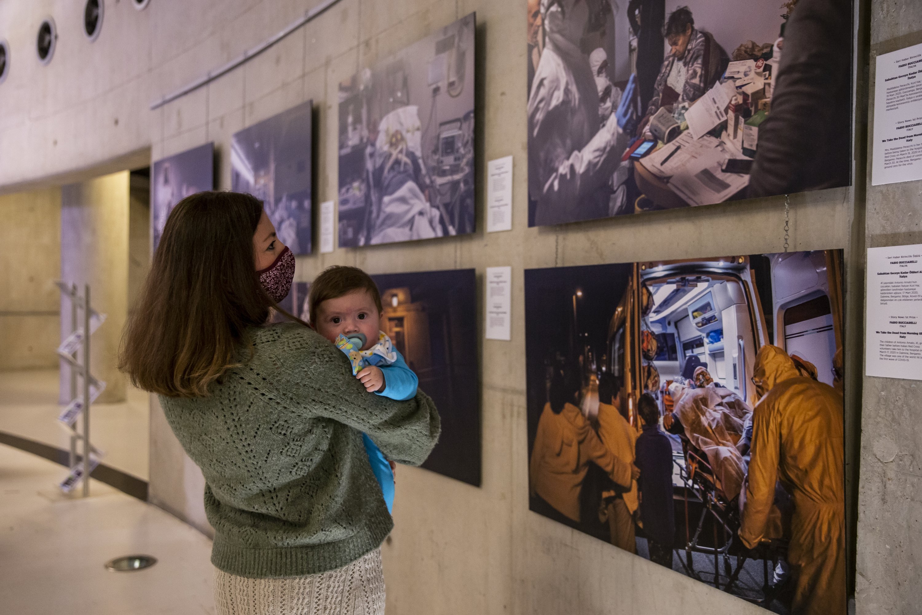A visitor with her baby examines some photos from the exhibition at the CerModern Arts Center, Ankara, Turkey, October 11, 2021. (AA Photo)