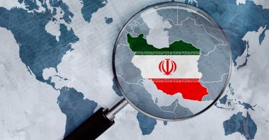 An illustration shows a magnifying glass zooming in on the flag of the Islamic Republic of Iran depicted in the shape of the country on a world map. (Photo by Shutterstock)