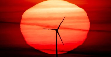 The sun rises behind a wind turbine in Frankfurt, Germany, Sept. 15, 2020. (AP Photo)