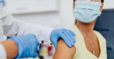 A nurse giving shot or vaccine to a patient's shoulder. (Shutterstock Photo)