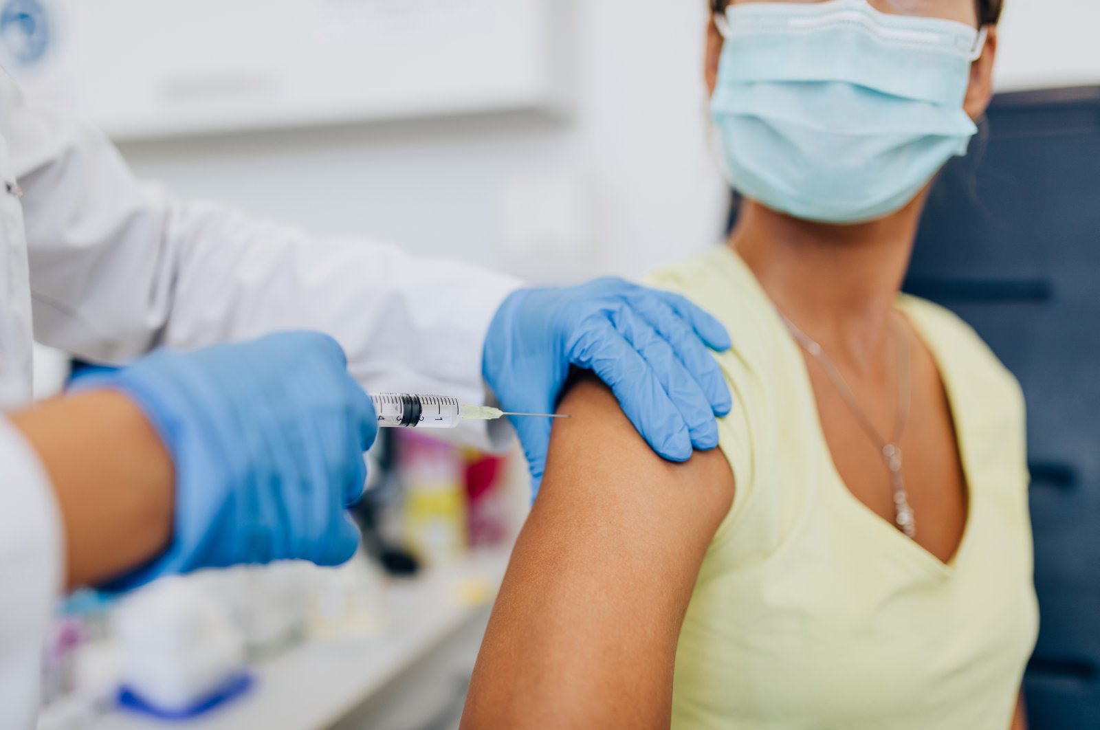 A nurse giving shot or vaccine to a patient's shoulder. (Shutterstock Photo)