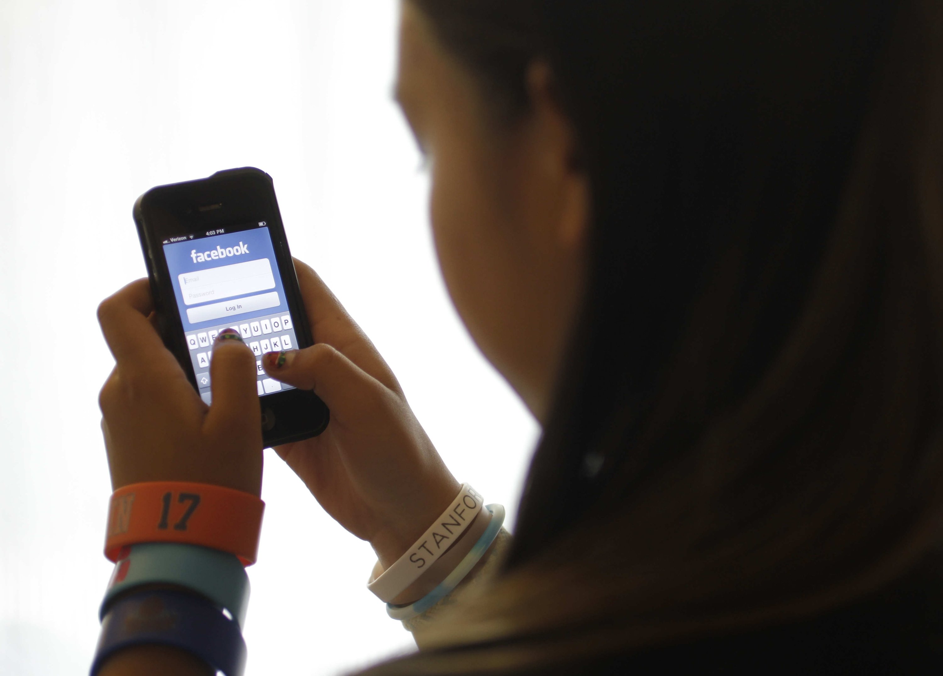 An unidentified 11-year-old girl logs into Facebook on her iPhone at her home in Palo Alto, California, U.S., June 4, 2012. (AP Photo)