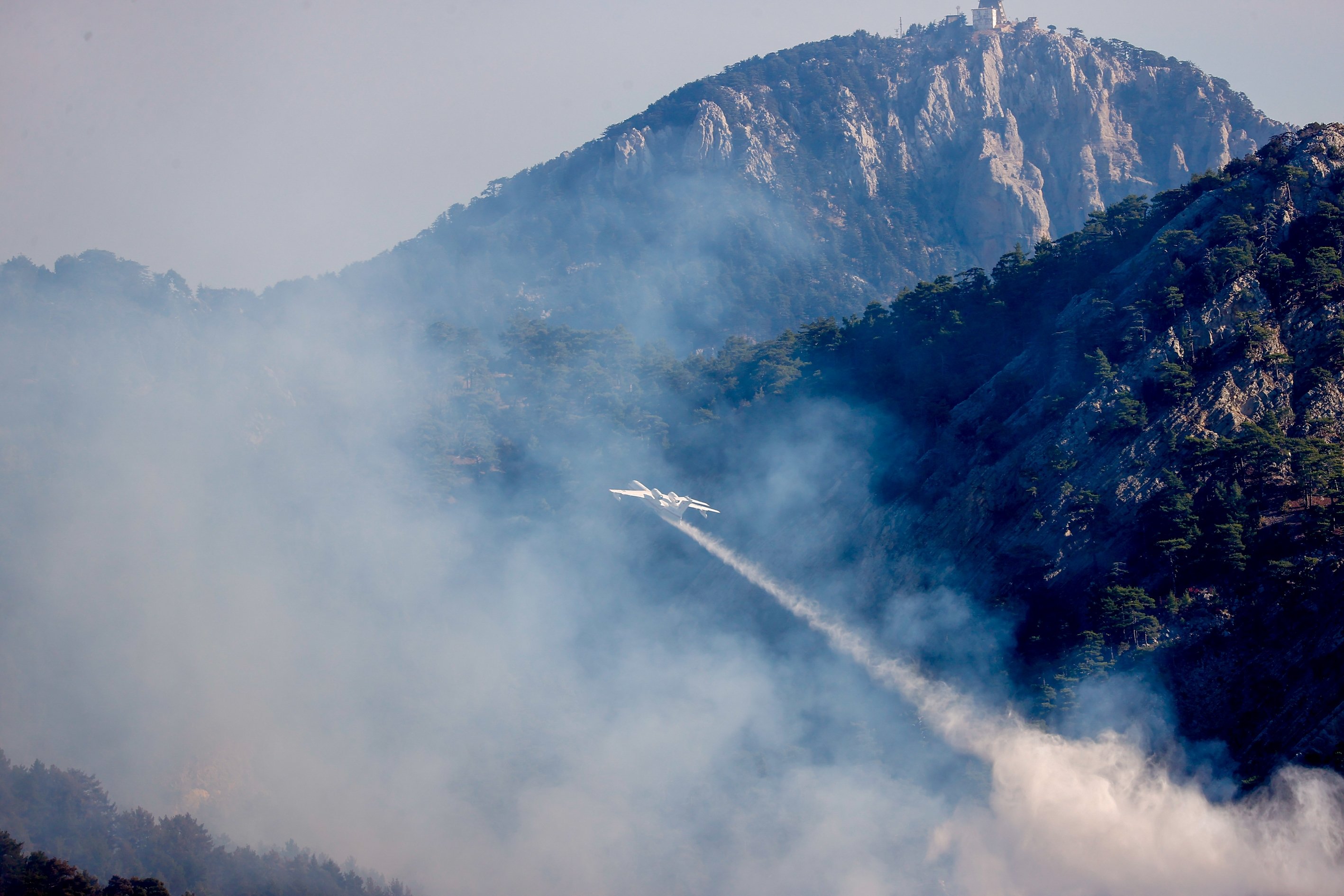 A plane participates in efforts to put out a wildfire in Kemer district of Antalya, Turkey, Oct. 13, 2021. (AA Photo)