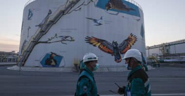 Workers stand in front of a huge water tank at one of the largest petrochemical complexes in the world 'ZapSibNeftekhimin' in Tobolsk, Tyumen region, Russia, Sept. 24, 2021. (EPA Photo)